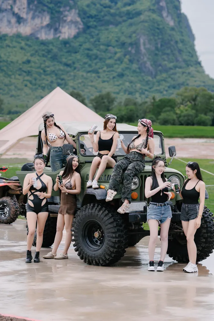 กลุ่มลูกค้าถ่ายรูปหมู่กับรถบักกี้และรถออฟโรดบนลานกว้าง มีแนวเขาเป็นฉากหลัง